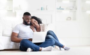 A homeowner and real estate agent reviewing a home maintenance checklist in a tidy living room.